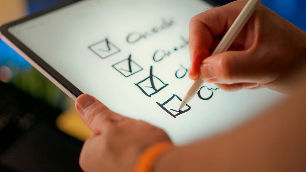 UAE Market Entry Checklist for Global Brands (Step-by-Step Guide) Close-up of a digital checklist being marked off on a tablet with a stylus pen.
